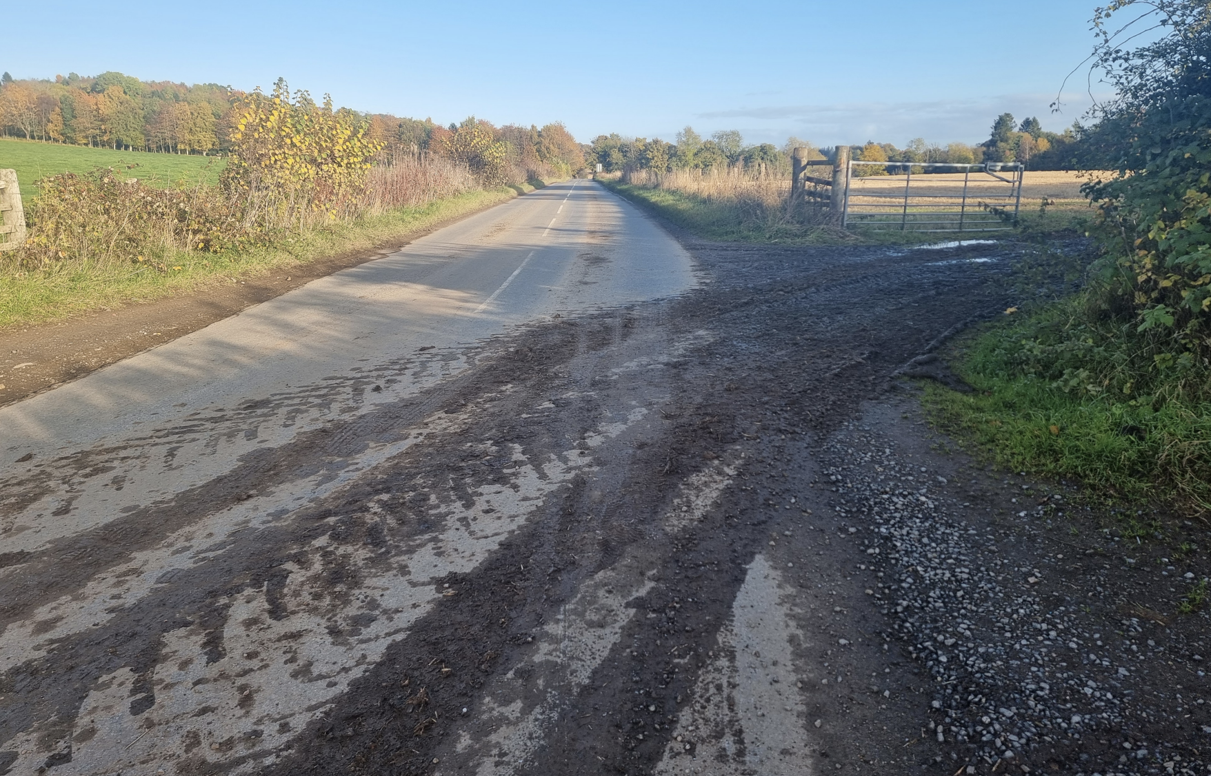Tractor tyre tracks from field with mud over road