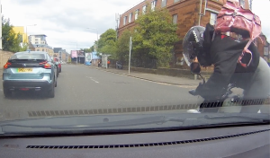 Biker coming off motorcycle when car pulls across her path at a jucntion