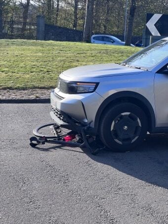 Bicycle trapped under wheels of a car