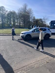 Bicycle underneath front wheels of car on a roundabout